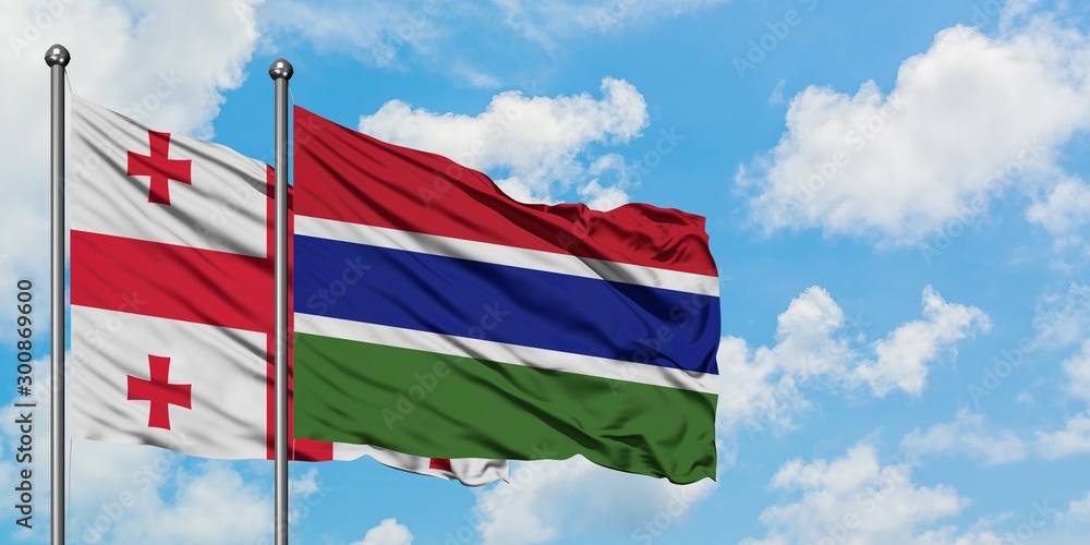 Georgia and Gambia flag waving in the wind against white cloudy blue sky together. Diplomacy concept, international relations.