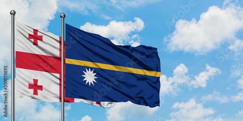 Georgia and Nauru flag waving in the wind against white cloudy blue sky together. Diplomacy concept, international relations.