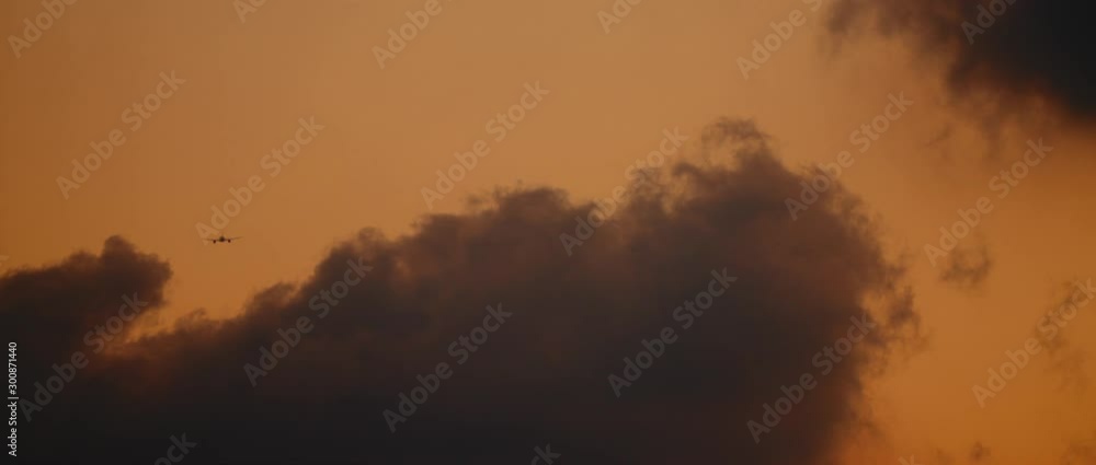 Plane flying into the clouds, at sunset sky. Slow motion, BMPCC 4K. Copy space Plane flying into the clouds, at sunset sky. Slow motion, BMPCC 4K. Copy space
