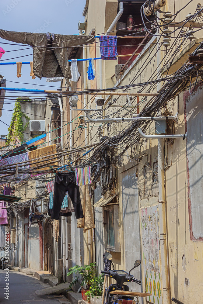 Electric wires and laundry in a narrow street in the old city neighborhood of Shanghai