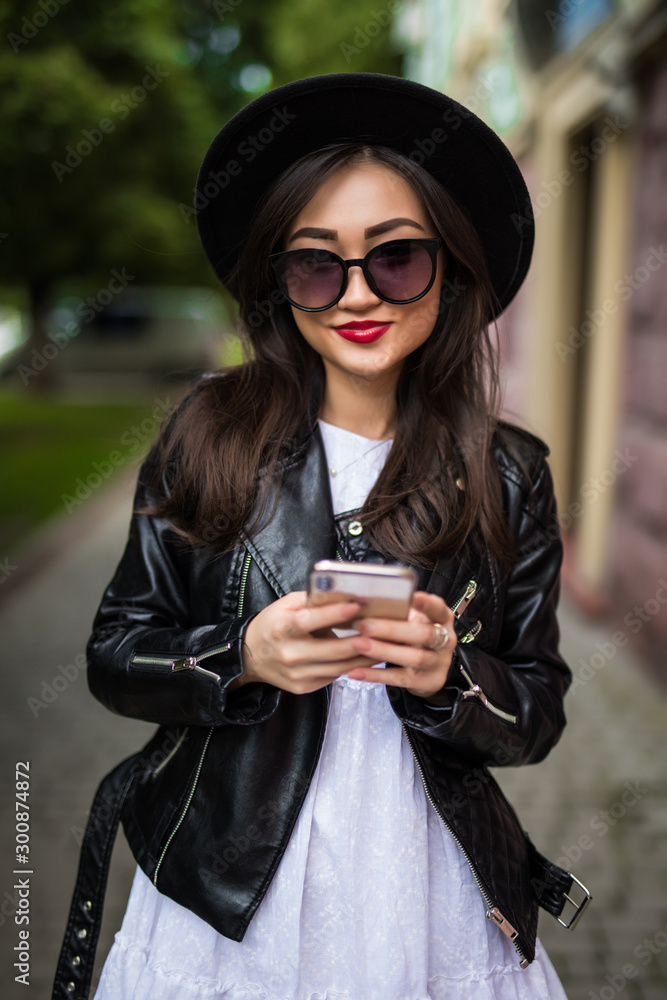 Asian woman using smart phone on city street
