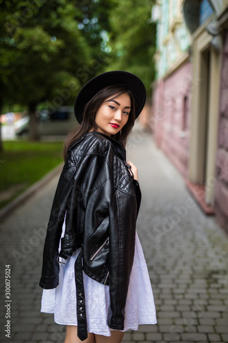 Beauty on the go. Rear view of attractive young asian woman looking away while walking down the street outdoors © dianagrytsku