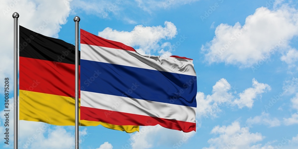 Germany and Thailand flag waving in the wind against white cloudy blue sky together. Diplomacy concept, international relations.