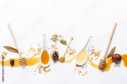 Photography white spoons and honey sticks, with spilled honey,