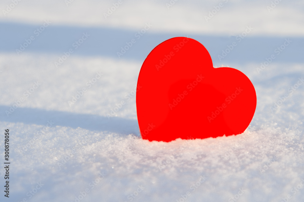 Red paper heart on a snowdrift close up, with place for your text.