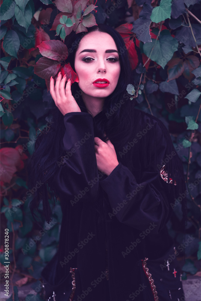 Young fashionable woman in a romantic autumn scenery with dark green red leaves Young fashionable woman in a romantic autumn scenery with dark green red leaves