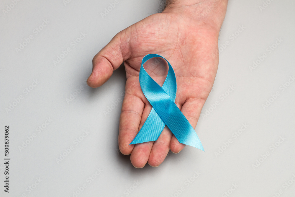 Campaña de concientización sobre la salud del hombre y el cáncer de próstata  en noviembre. Mano sosteniendo cinta lazo celeste. Vista desde arriba. Copy  space foto de Stock | Adobe Stock