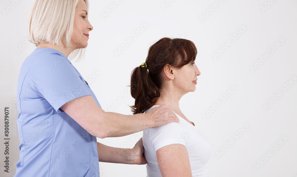 Female patient and doctor have consultation in hospital. Picture of middle aged woman during rehabilitation in professional clinic Female patient and doctor have consultation in hospital. Picture of middle aged woman during rehabilitation in professional clinic