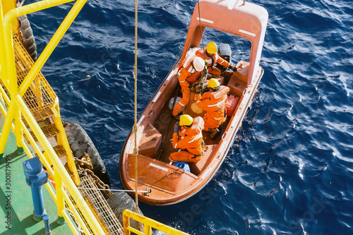 Fast rescue craft being deployed from a construction barge at oil field photo