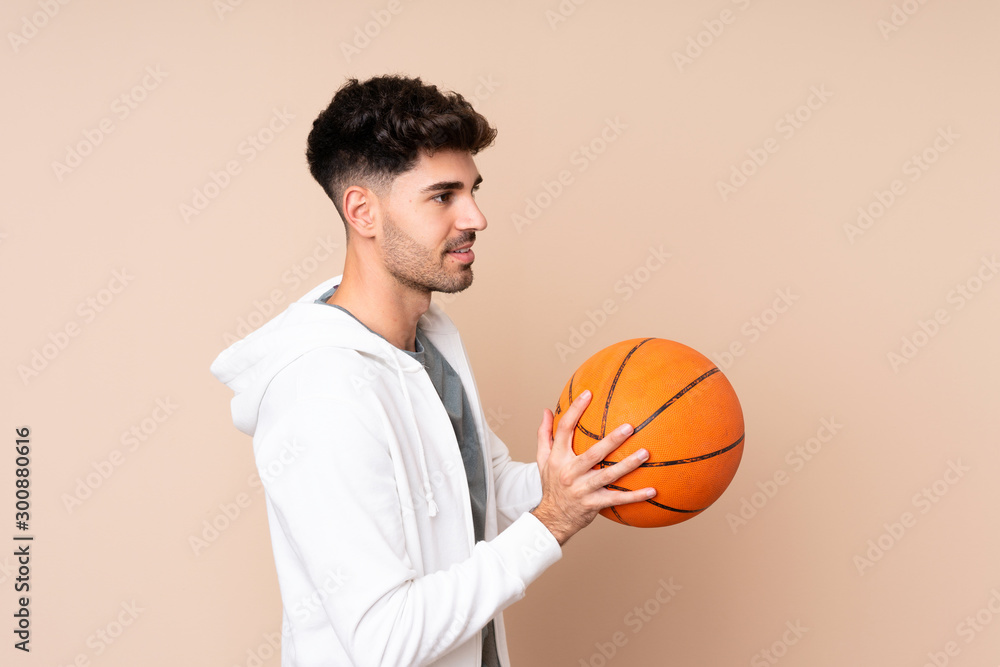 Young man over isolated background playing basketball