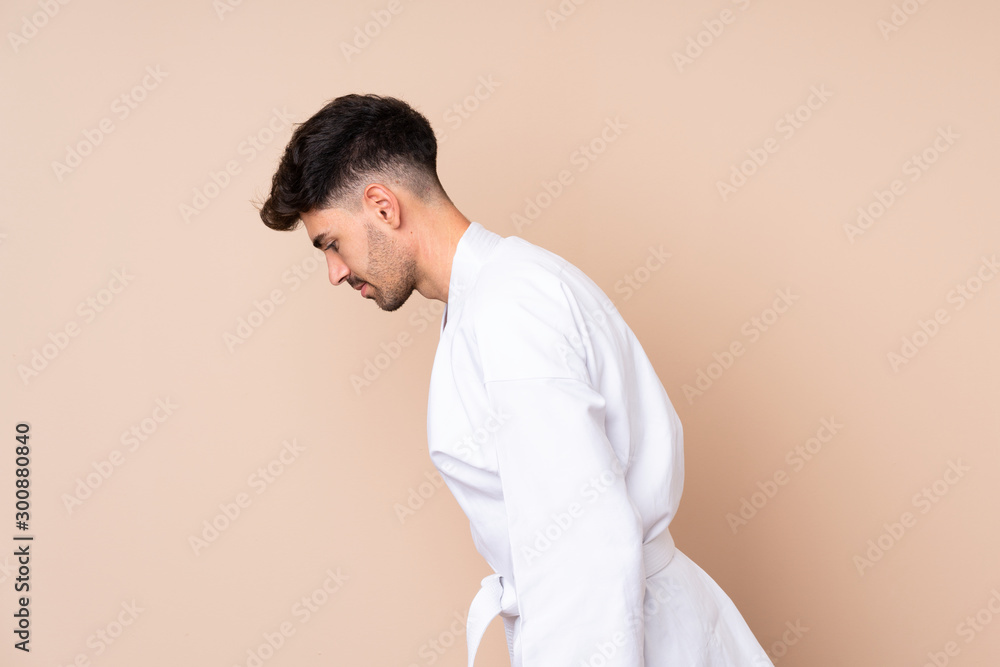 Young man over isolated background doing karate and saluting Young man over isolated background doing karate and saluting