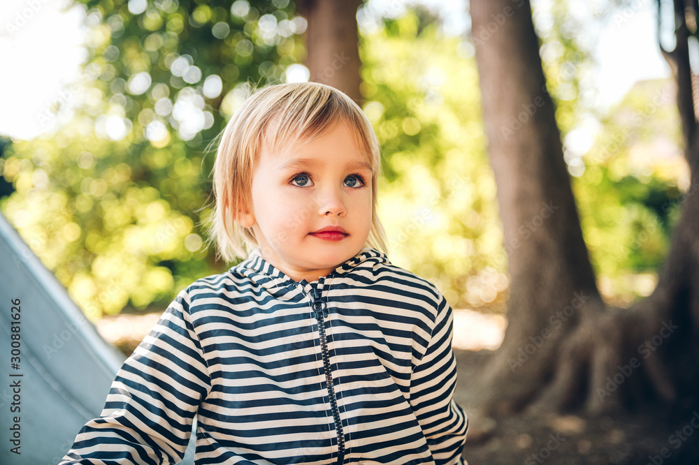 Outdoor portrait of happy toddler girl playing on playground, active child having fun in kids park Outdoor portrait of happy toddler girl playing on playground, active child having fun in kids park