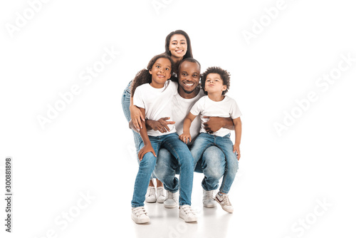 happy african american woman embracing kids and husband on white background