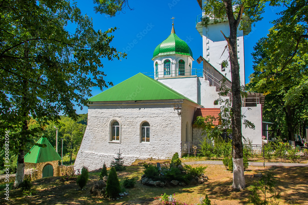 Fototapeta premium Orthodox Church with green domes and white walls. Monastery
