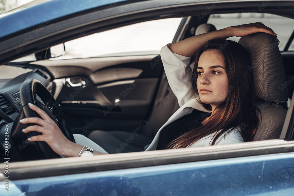 Fashion Stylish Driver Girl in White Suit Sitting in the Car Fashion Stylish Driver Girl in White Suit Sitting in the Car