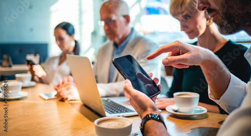 Businessman using smartphone during meeting in cafe