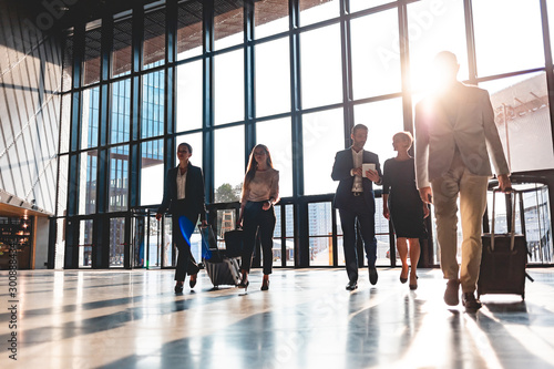 Foto Group of business people walking in airport hall
