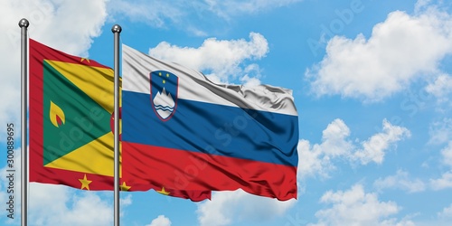 Grenada and Slovenia flag waving in the wind against white cloudy blue sky together. Diplomacy concept  international relations.