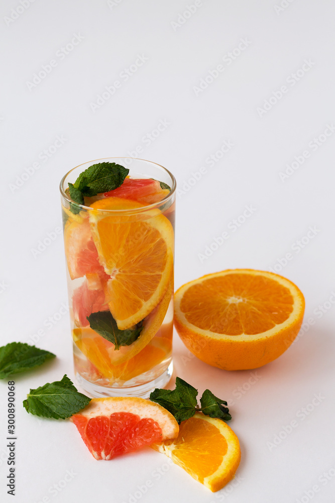 Orange. Detox citrus cocktail. healthy lifestyle. cocktail with slices of fresh orange with green mint leaves on white background. Orange. Detox citrus cocktail. healthy lifestyle. cocktail with slices of fresh orange with green mint leaves on white background.