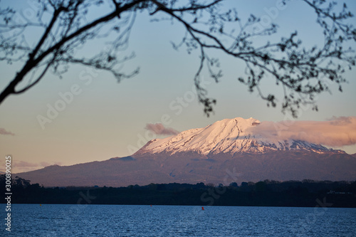 The Llanquihue lake with the magnificent Calbuco volcano and the moon. View from Puerto Varas near Puerto Montt, Chile. © Alex