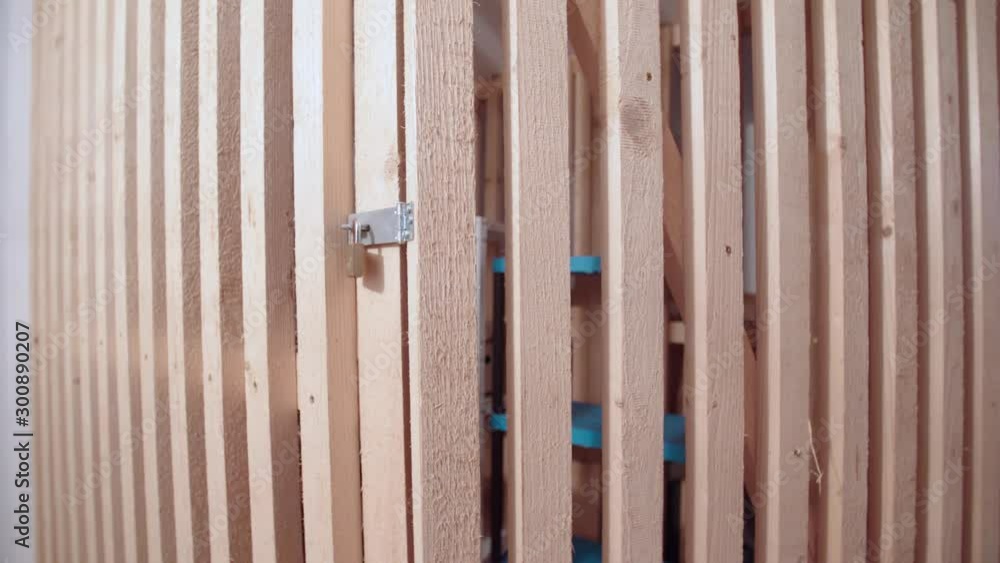 Locked up basement space protected with wooden fence 4K. Dolly slide of the wooden fence door in focus with personal storage in background. Locked up basement space protected with wooden fence 4K. Dolly slide of the wooden fence door in focus with personal storage in background.