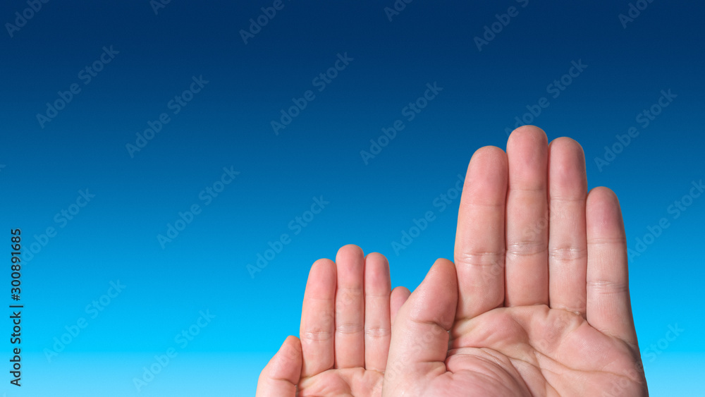 Two voting hands, one is bigger, another is smaller, at blue gradient sky with paste space, details, closeup Two voting hands, one is bigger, another is smaller, at blue gradient sky with paste space, details, closeup