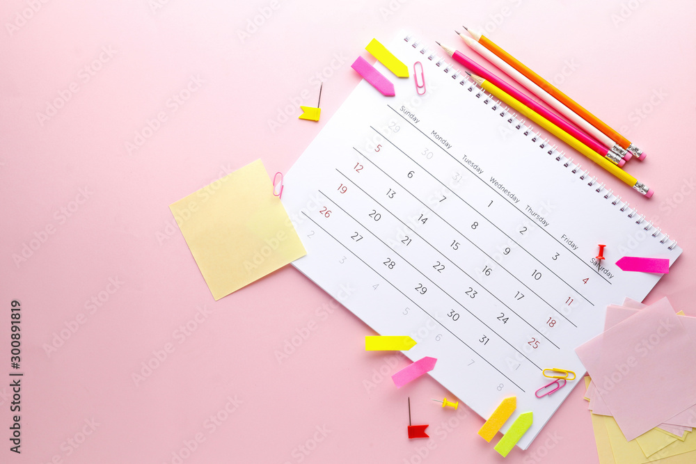Planning calendar on a pink background with pins, pencils, stickers .. Important date. Place for text. Planning concept. Planning calendar on a pink background with pins, pencils, stickers .. Important date. Place for text. Planning concept.