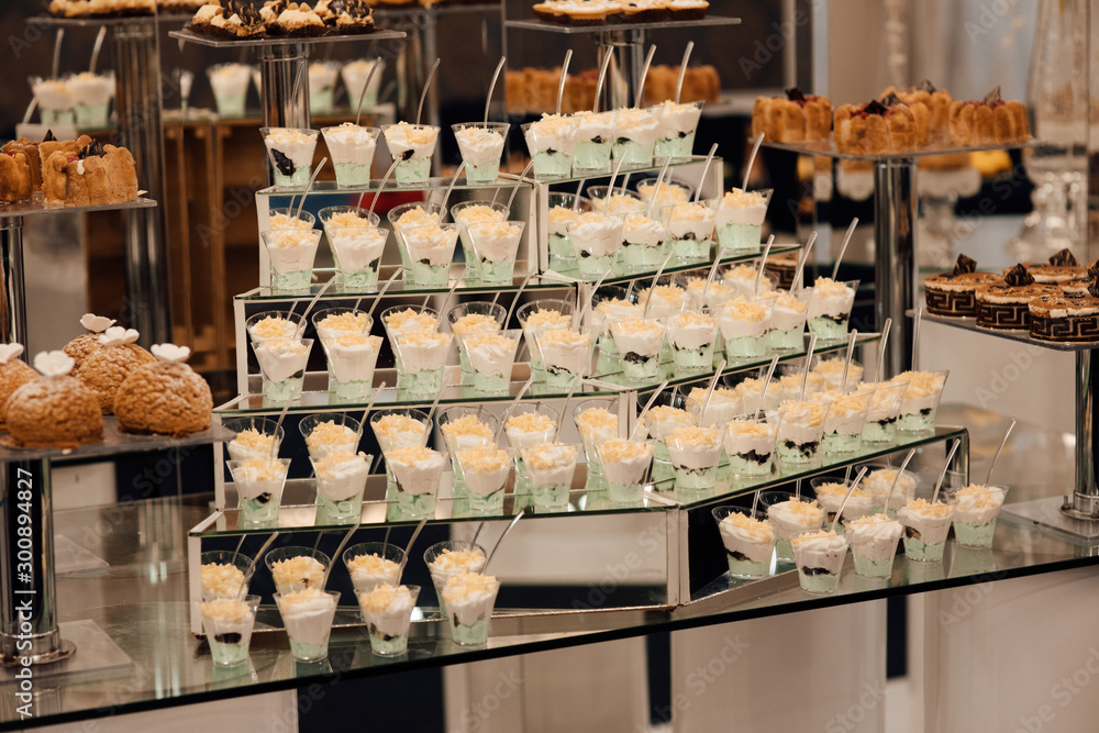 Refrigerated cups of chocolate ice cream. Sweet table on the wedding with delicious desserts. Candy bar. Table with sweet candies. Wedding cake. Dessert table at wedding reception