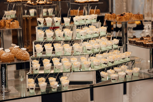 Refrigerated cups of chocolate ice cream. Sweet table on the wedding with delicious desserts. Candy bar. Table with sweet candies. Wedding cake. Dessert table at wedding reception