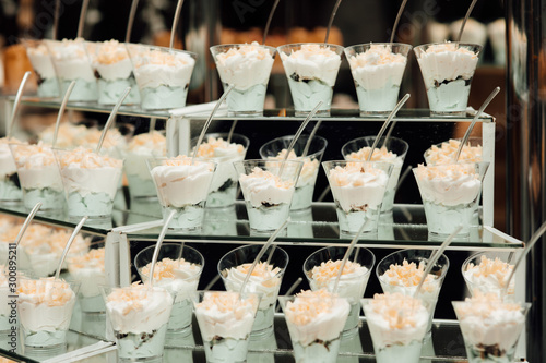 Refrigerated cups of chocolate ice cream. Sweet table on the wedding with delicious desserts. Candy bar. Table with sweet candies. Wedding cake. Dessert table at wedding reception