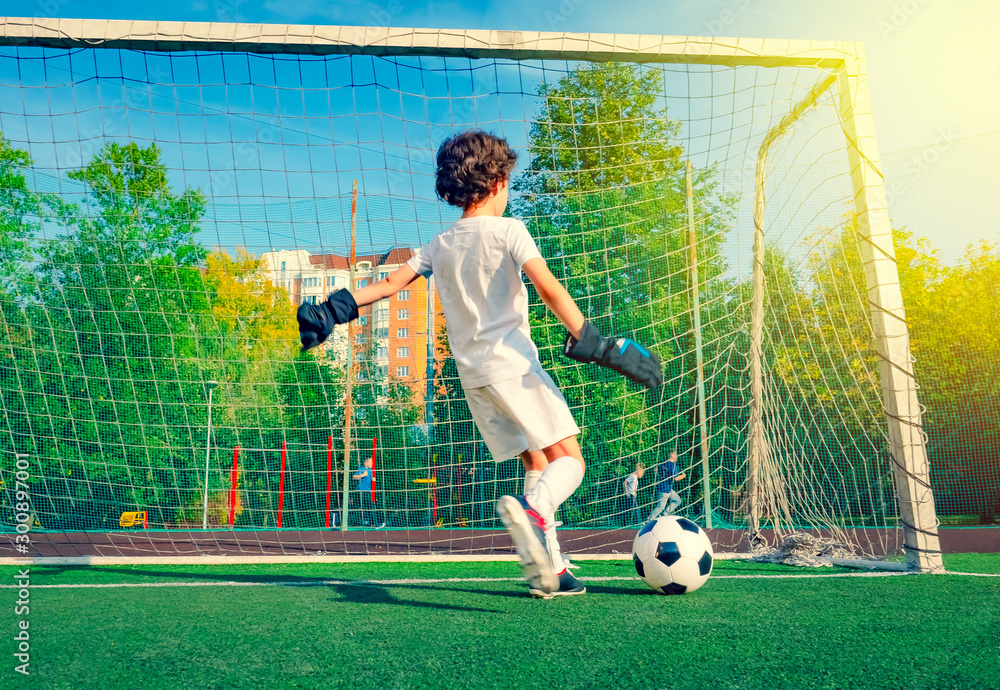 Young soccer goalie attempting to make a save. little soccer goalkeeper with gloves. Kids soccer champion. Boy goalkeeper in football sportswear on stadium with ball. Sport concept. Selective focus. S...