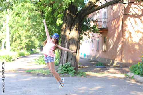 Pretty cute female girl child jumping and having fun in yard on street. photo