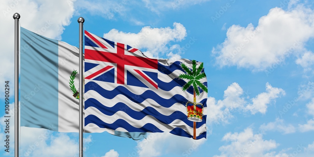 Guatemala and British Indian Ocean Territory flag waving in the wind against white cloudy blue sky together. Diplomacy concept, international relations.