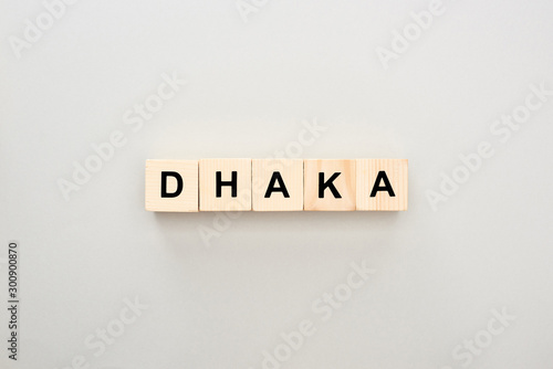 top view of wooden blocks with Dhaka lettering on grey background