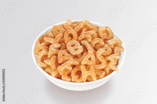 Fried and Spicy Alphabet, ABCD, A-B-C-D, Snacks or Fryums (Snacks Pellets) served in a white bowl. selective focus - Image photo