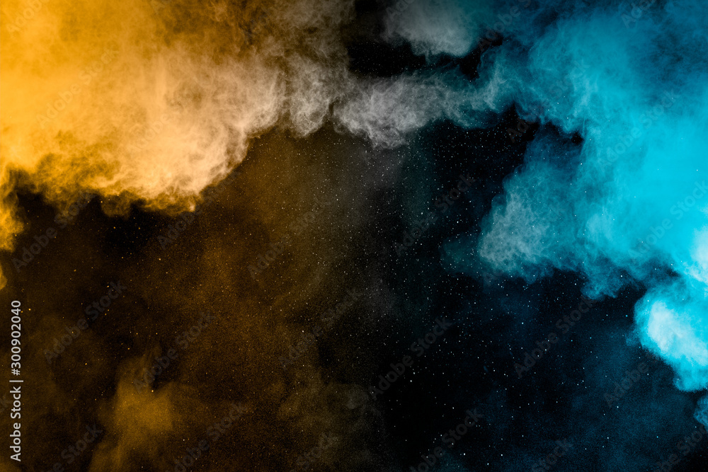 Yellow blue powder explosion cloud on black background. Freeze motion of color dust particles splashing. Yellow blue powder explosion cloud on black background. Freeze motion of color dust particles splashing.