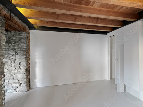 Vászonkép a empty room with wooden ceiling and concrete floor whose walls are of stones