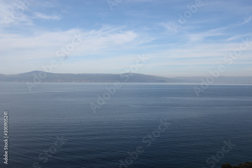Blue sea and mountain landscape. Blue sky and fluffy clouds landscape.