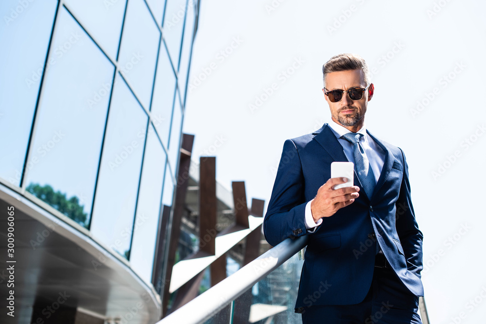 handsome man in suit with hand in pocket using smartphone handsome man in suit with hand in pocket using smartphone