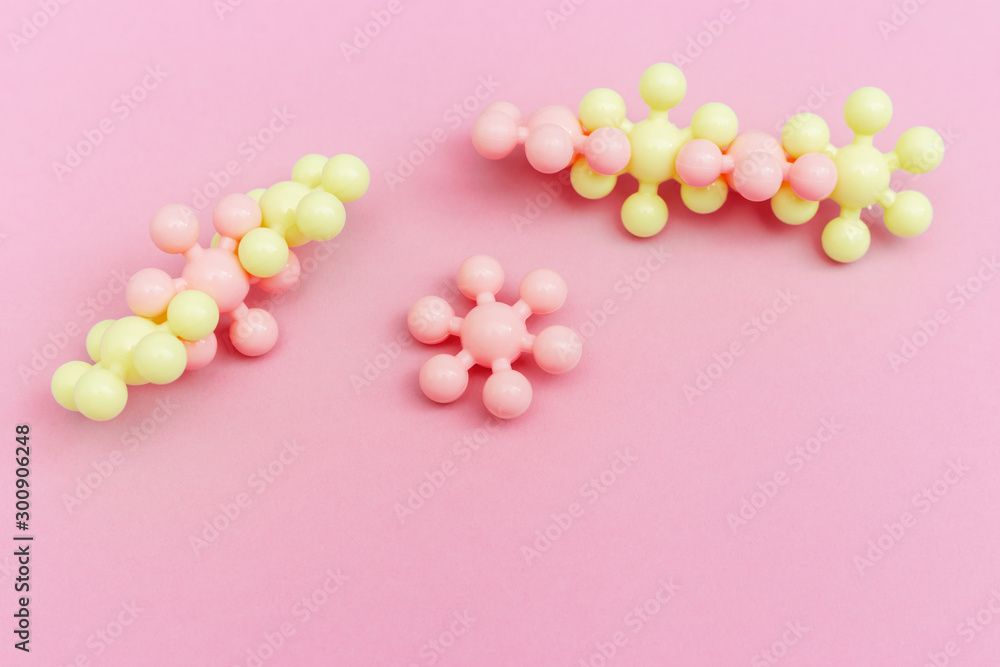 Abstract molecules on pink paper. Medical background for banner or flyer. Molecular structure with pink and yellow spherical particles.