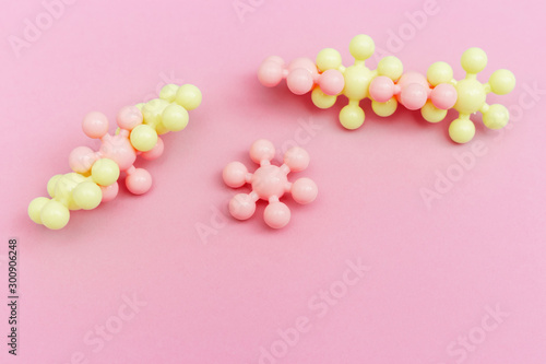 Abstract molecules on pink paper. Medical background for banner or flyer. Molecular structure with pink and yellow spherical particles.