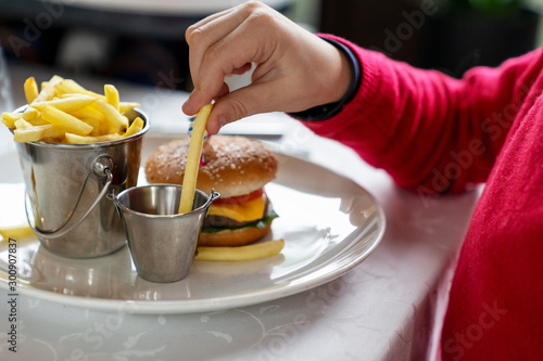 Kids favourite food - mini burger and french fries. Family dinner in restaurant.
