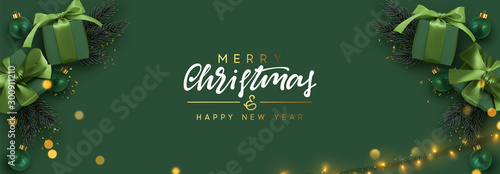 Holiday banner Merry Christmas and Happy New Year. Xmas design with realistic objects, realistic dark green color gift box, balls, light lamps garland, glitter gold confetti. Festive horizontal poster photo