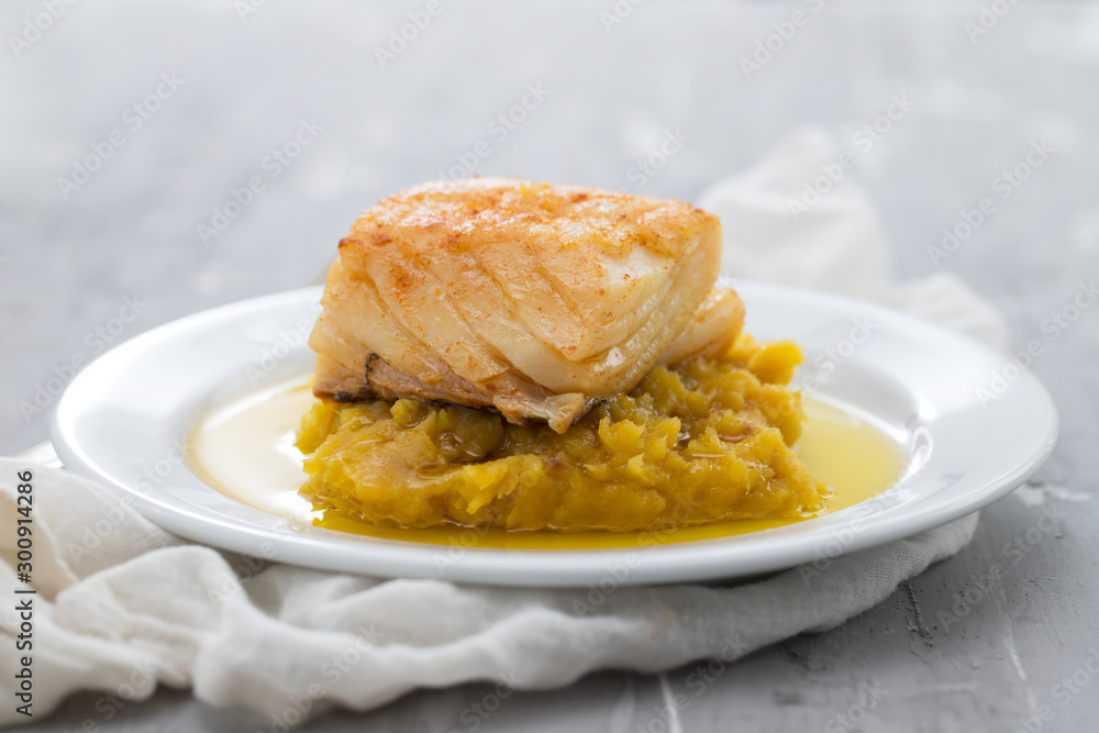 cod fish with sweet potato and olive oil on white dish