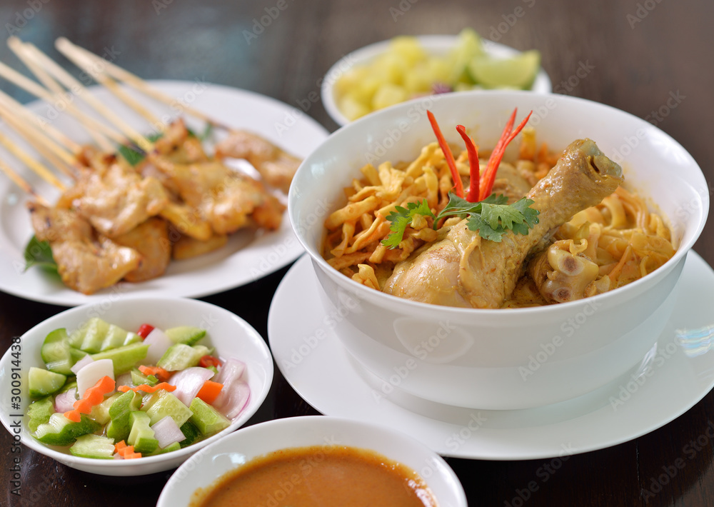 Khao Soi Chicken, northern Thai noodle dish with chicken and coconut curry soup, shown with crispy noodles and other vegetables Khao Soi Chicken, northern Thai noodle dish with chicken and coconut curry soup, shown with crispy noodles and other vegetables