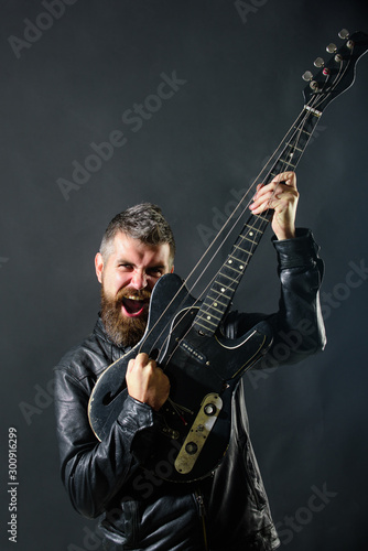 Music, concert, entertainment. Guitarist with electric bass guitar. Music, musical instrument. Handsome rock star wearing leather jacket holds electric guitar. Rock star with guitar. Music festival.