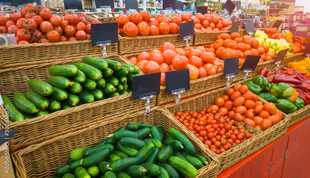 Food market vegetables with blank price tag labels. Various fresh ripe cucumbers, tomatoes, peppers and other agriculture products on marketplace sale.