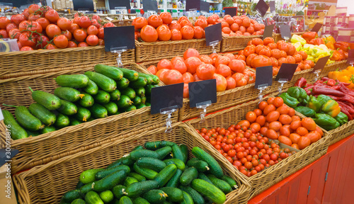 Food market vegetables with blank price tag labels. Various fresh ripe cucumbers, tomatoes, peppers and other agriculture products on marketplace sale. © Mediagfx