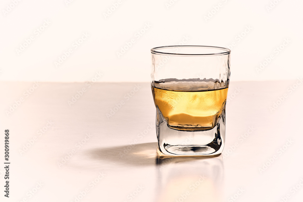 Front view and isolated whiskey glass with golden light Front view and isolated whiskey glass with golden light