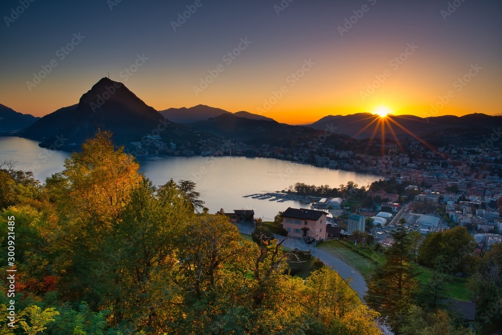 Stadtansicht von Lugano mit See und Berg San Salvatore bei Sonnenuntergang